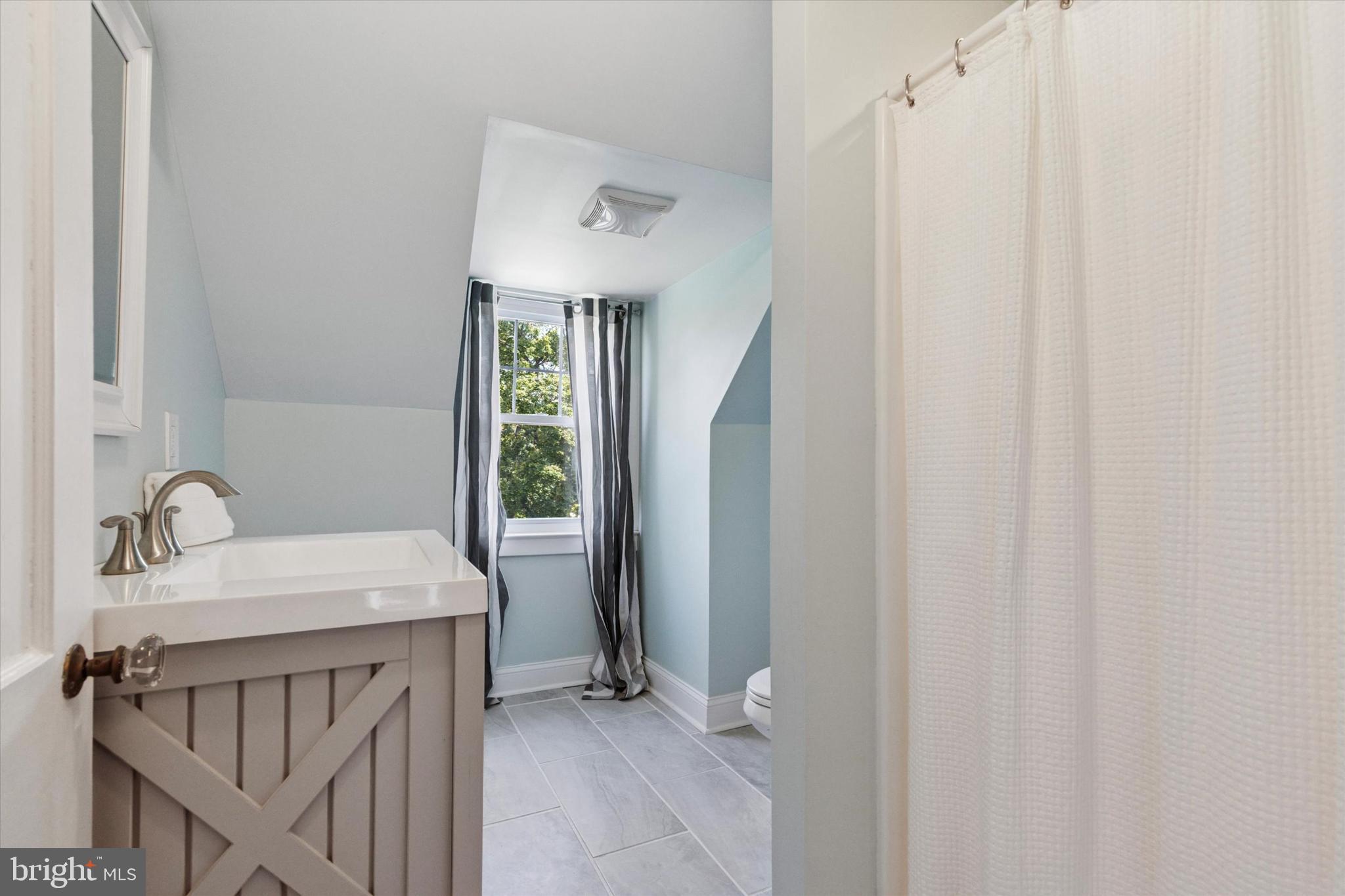 140 North Rolling Road Springfield, PA 19064 - Photo 20 of 34 a bathroom with a sink a mirror and a bathtub