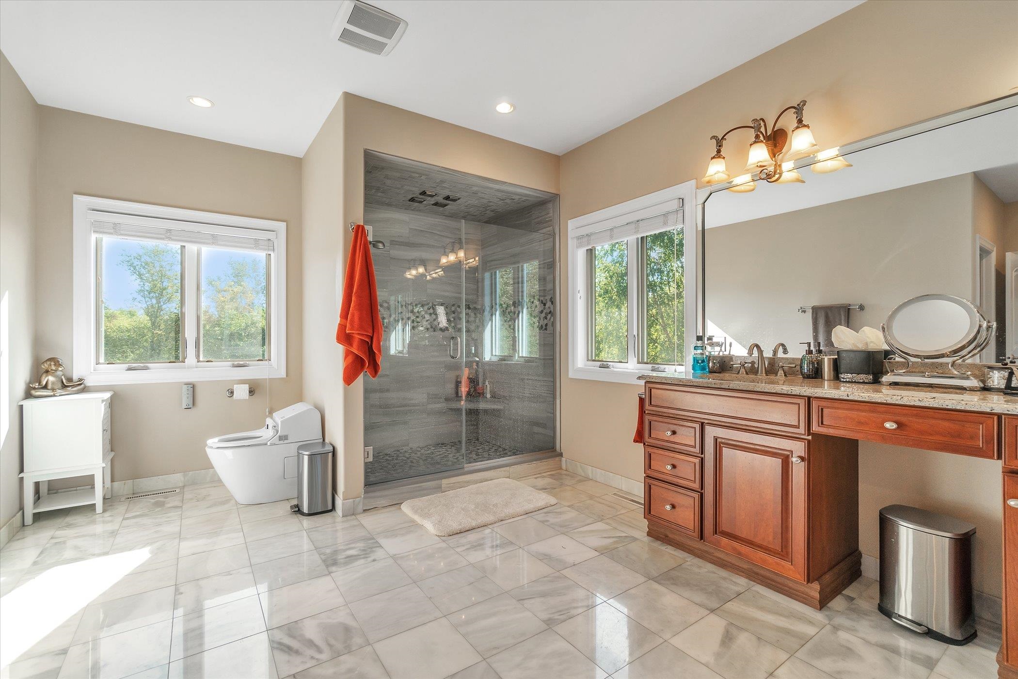 12535 Bellingham Road Caledonia, IL 61011 - Photo 27 of 57 a spacious bathroom with a granite countertop sink a toilet a mirror and a tub