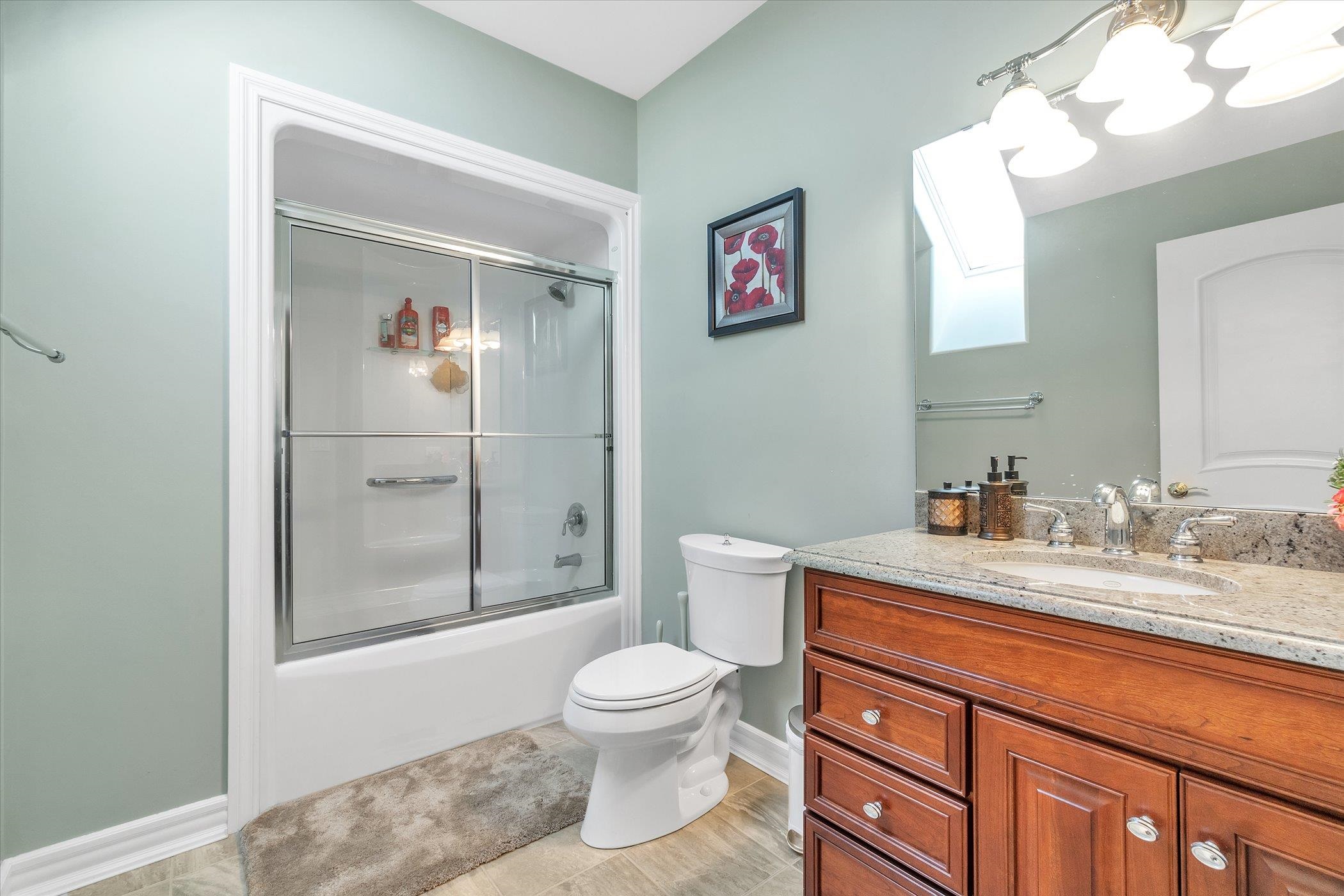 12535 Bellingham Road Caledonia, IL 61011 - Photo 35 of 57 a bathroom with a granite countertop toilet sink and mirror