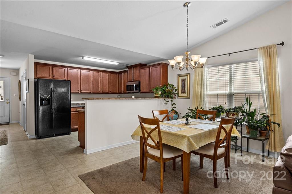 3005 Arthur Road, Unit 170 Indian Land, SC 29707 - Photo 25 of 38 a view of a dining room and livingroom with furniture wooden floor a chandelier