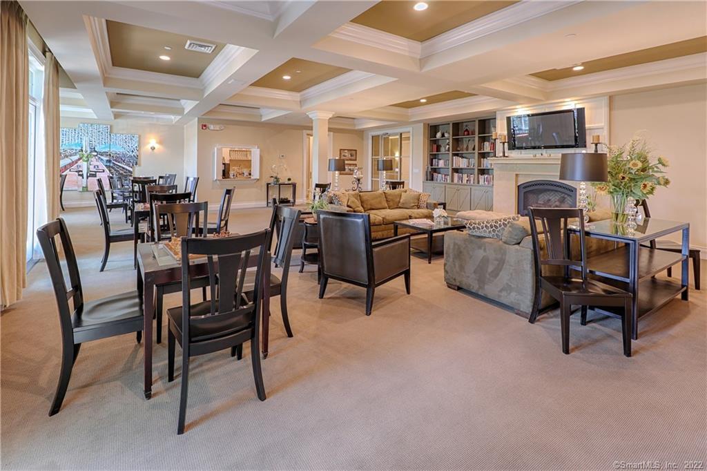 100 Stone Ridge Way, Unit 1H Fairfield, CT 06824 - Photo 15 of 30 a living room with furniture a fireplace and a table