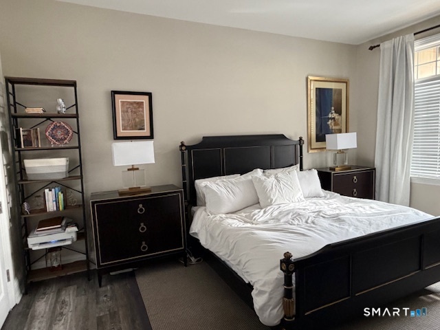 100 Stone Ridge Way, Unit 1H Fairfield, CT 06824 - Photo 17 of 30 a bedroom with a bed and wooden floor