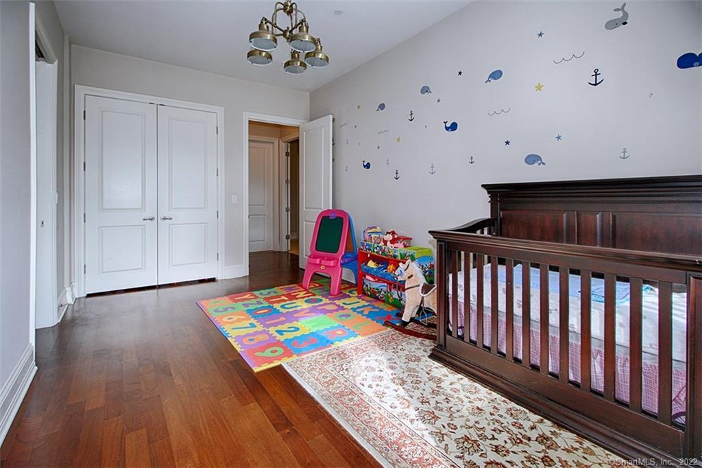 100 Stone Ridge Way, Unit 1H Fairfield, CT 06824 - Photo 23 of 30 a hallway with toys and wooden floor