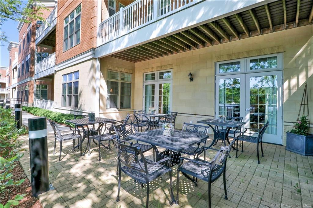 100 Stone Ridge Way, Unit 1H Fairfield, CT 06824 - Photo 28 of 30 a view of a patio with table and chairs and potted plants