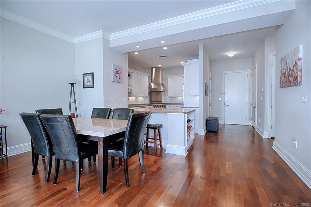 100 Stone Ridge Way, Unit 1H Fairfield, CT 06824 - Photo 8 of 30 a view of a dining room with furniture and wooden floor