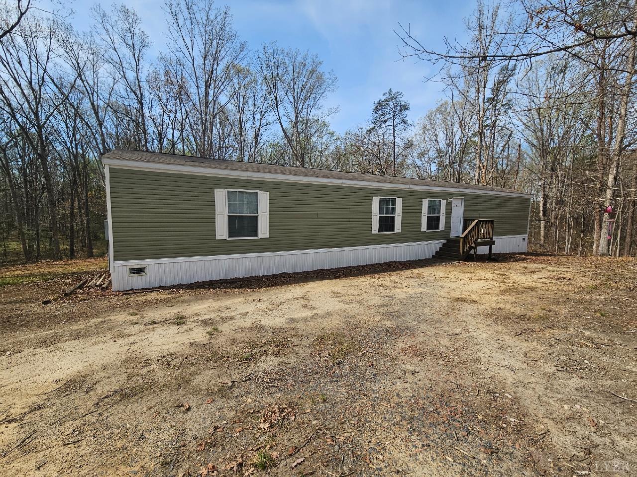 front view of house with yard and trees in the background