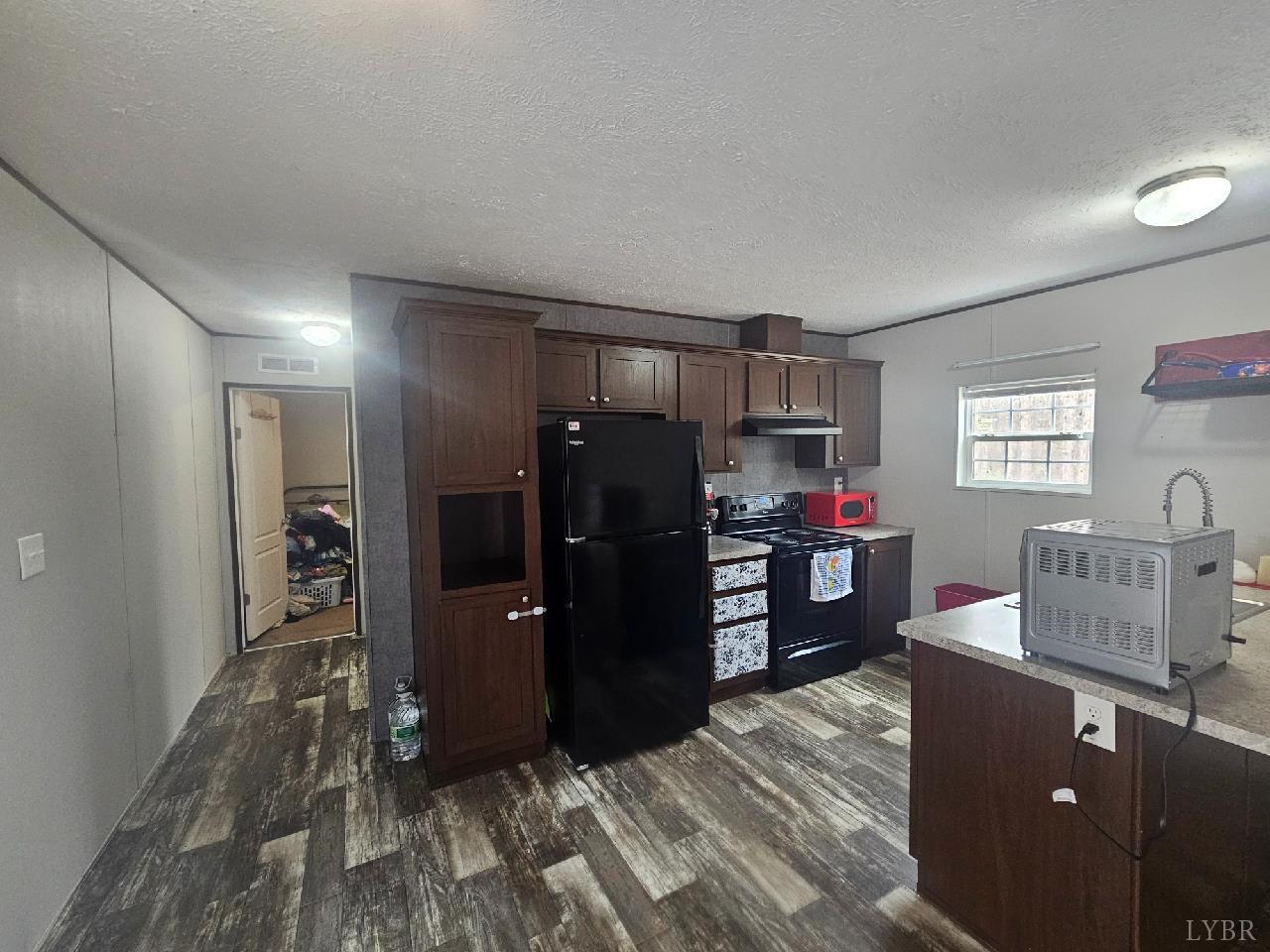 415 Plum Branch Road Lynchburg, VA 24504 - Photo 2 of 17 a kitchen with a refrigerator and a wooden cabinets
