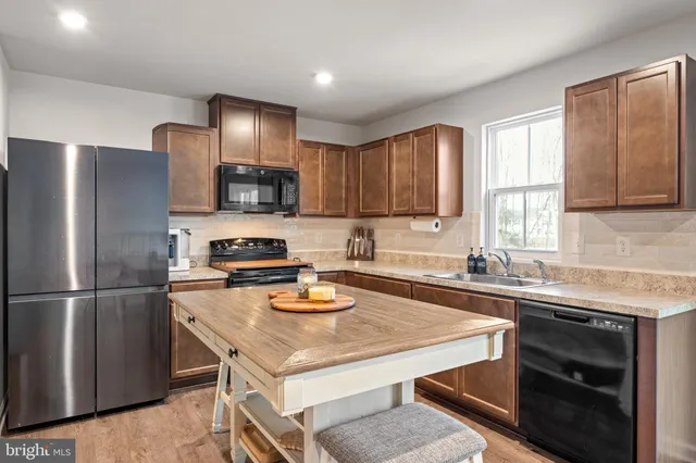 a kitchen with a appliances a sink cabinets and a window