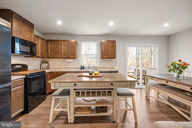 a kitchen with a stove a sink a microwave a dining table and chairs