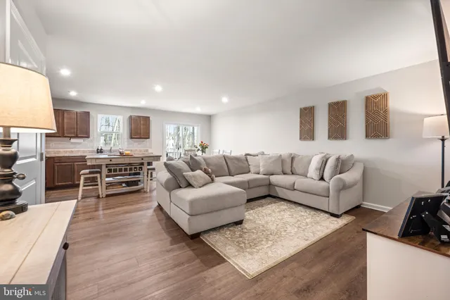 a living room with furniture and view of kitchen