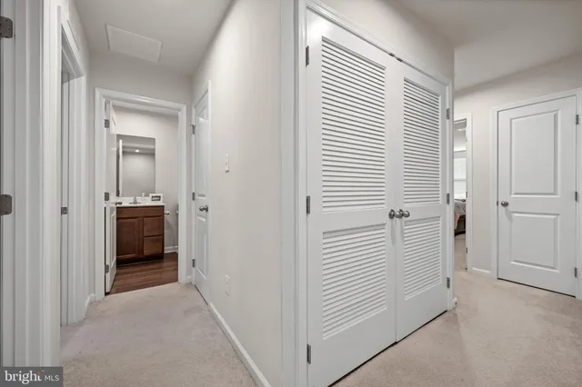a view of a hallway to rooms and stairs