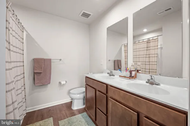 a bathroom with a granite countertop sink a toilet and a mirror