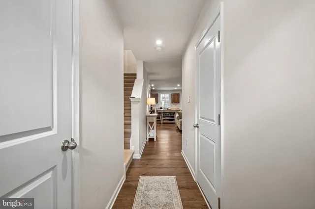 a view of a hallway with wooden floor and a living room