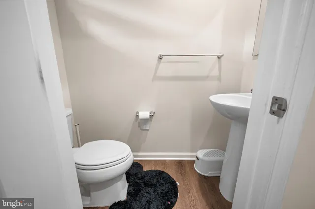 a white toilet sitting next to a bathroom sink and a mirror