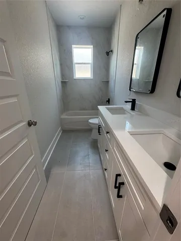 a bathroom with a sink a toilet a mirror and shower