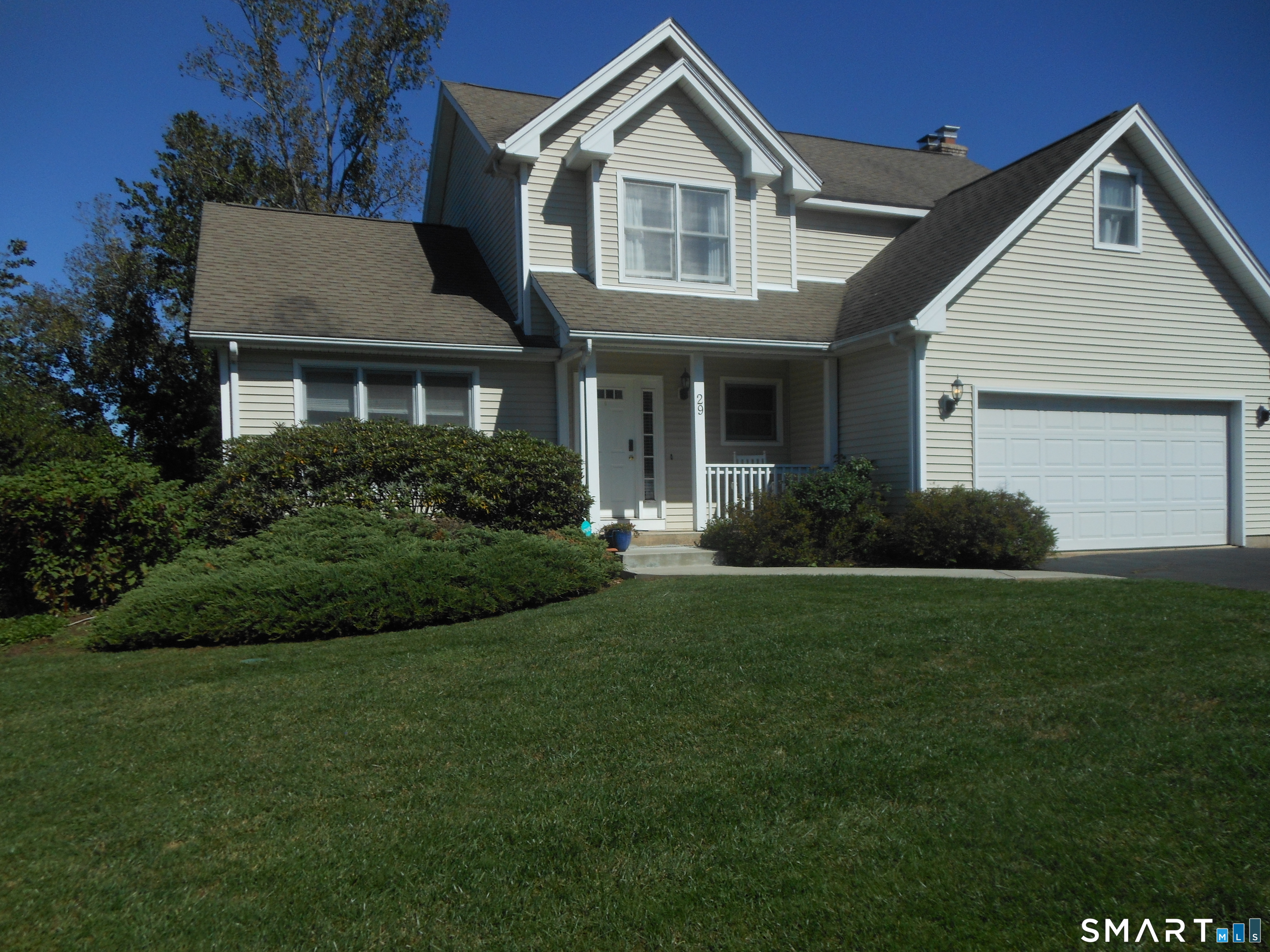 a front view of a house with a garden and plants