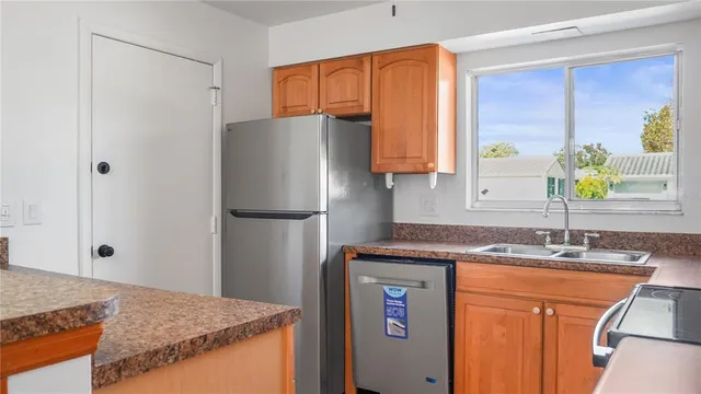 a kitchen with stainless steel appliances granite countertop a refrigerator and a sink