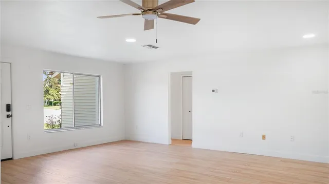 an empty room with fan and windows