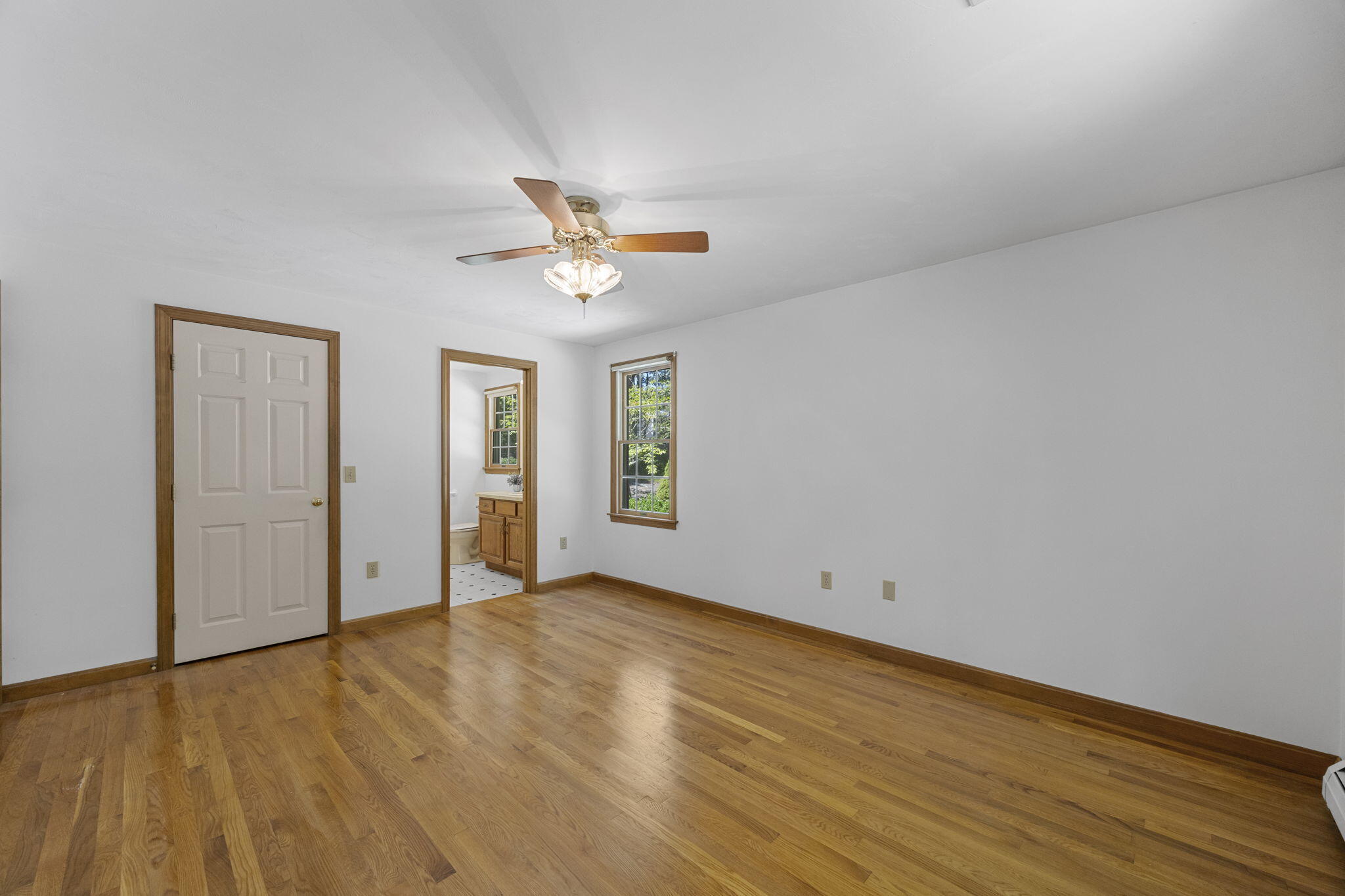 19 Fishermans Landing Road Brewster, MA 02631 - Photo 29 of 58 an empty room with wooden floor chandelier fan and windows