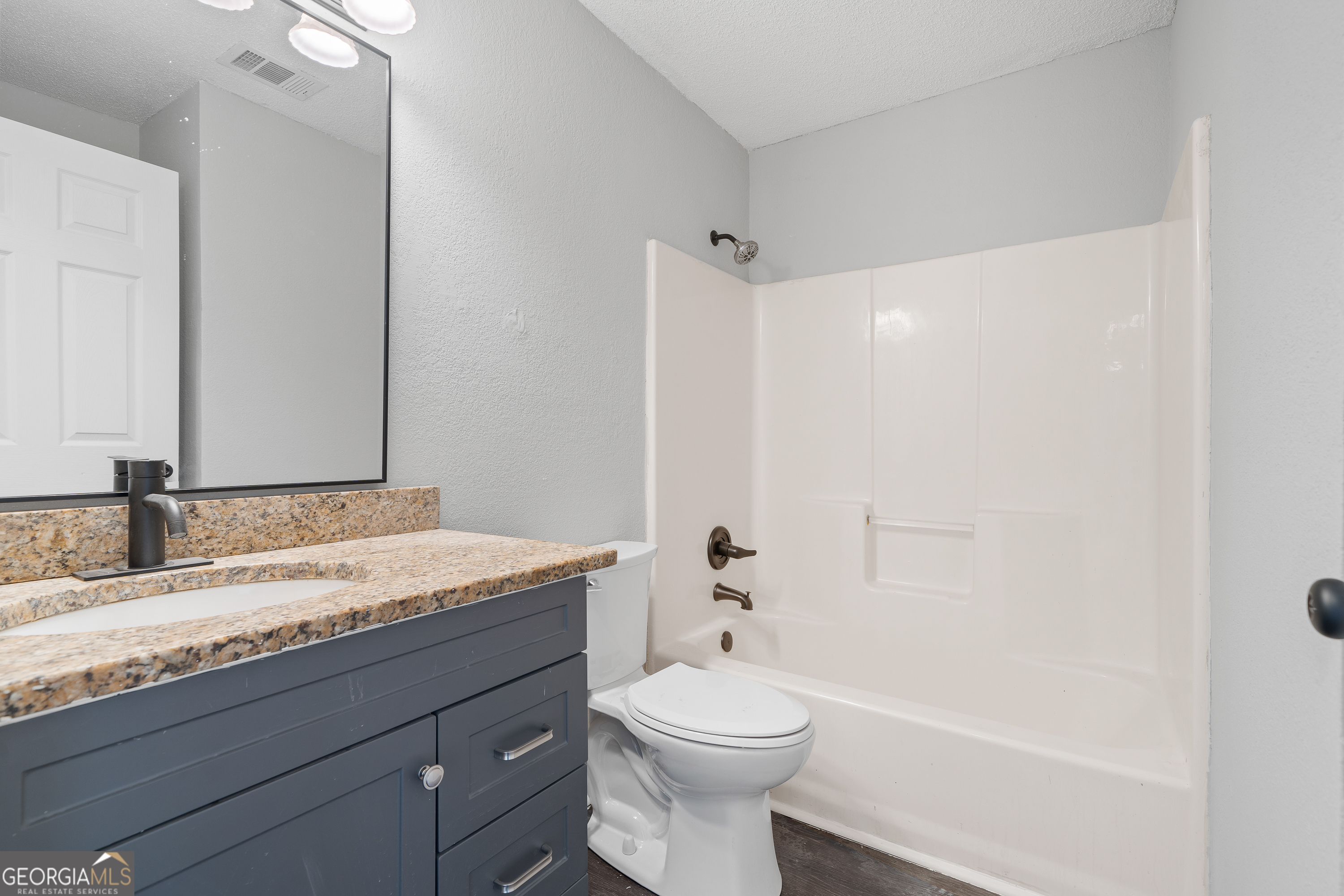 7513 Columbus Road Lizella, GA 31052 - Photo 21 of 54 a bathroom with a granite countertop sink toilet and shower