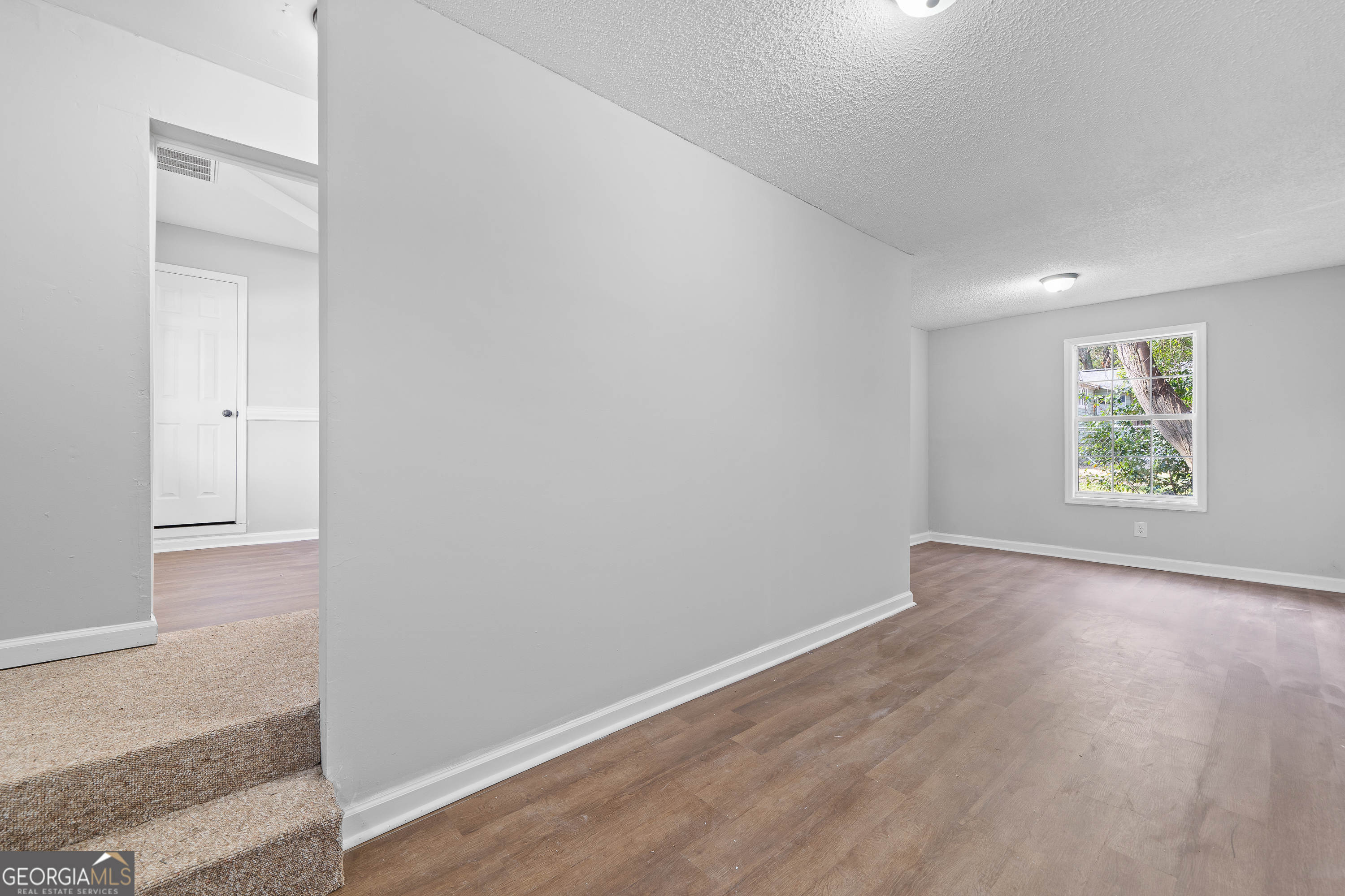 7513 Columbus Road Lizella, GA 31052 - Photo 35 of 54 an empty room with wooden floor and window