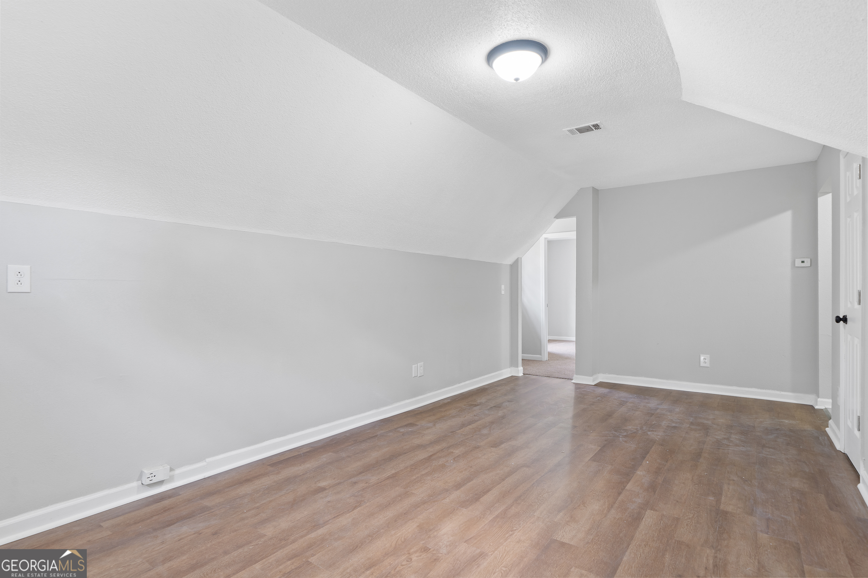 7513 Columbus Road Lizella, GA 31052 - Photo 46 of 54 an empty room with wooden floor and white walls