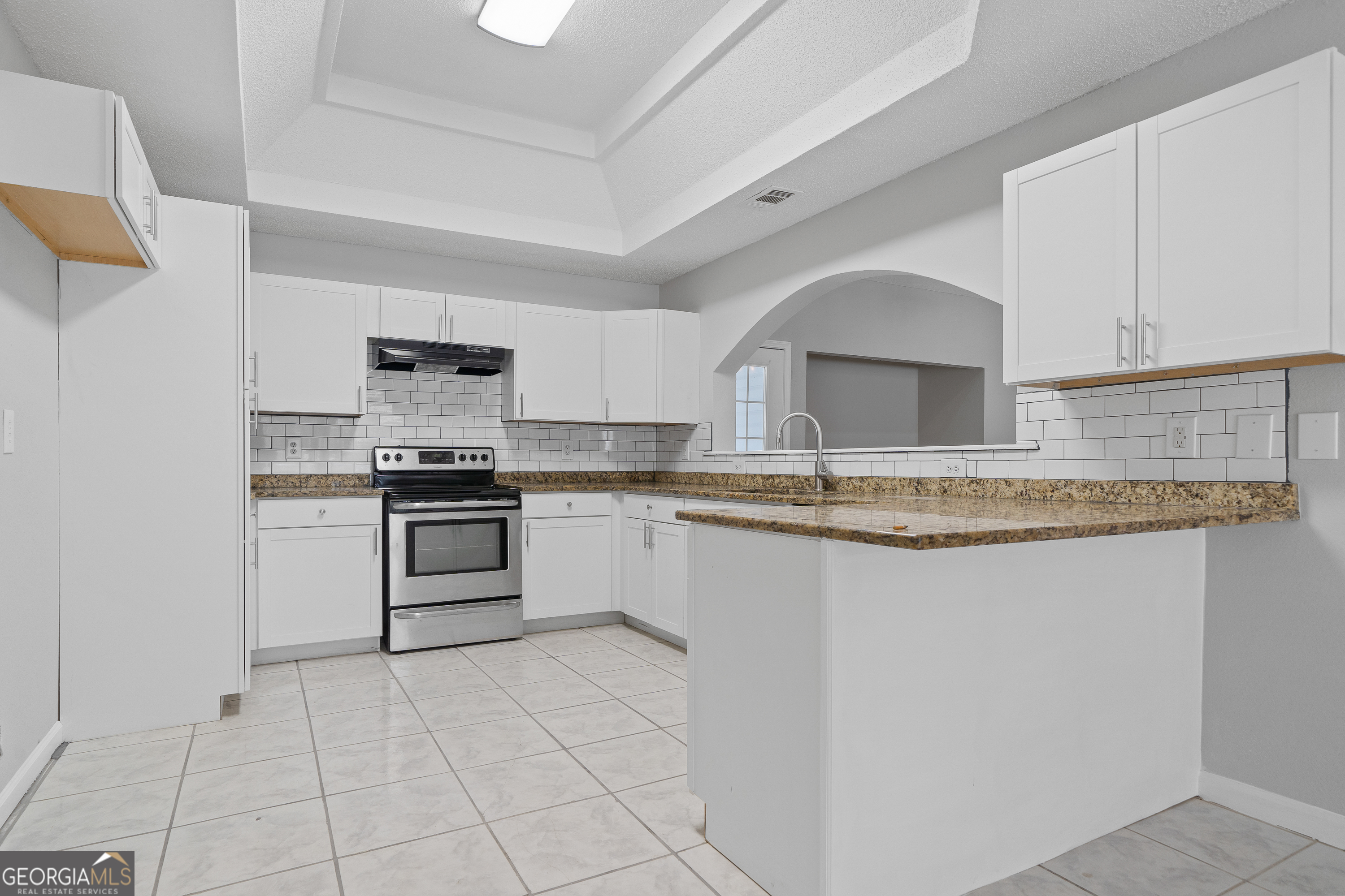 7513 Columbus Road Lizella, GA 31052 - Photo 7 of 54 a kitchen with granite countertop a stove sink and cabinets