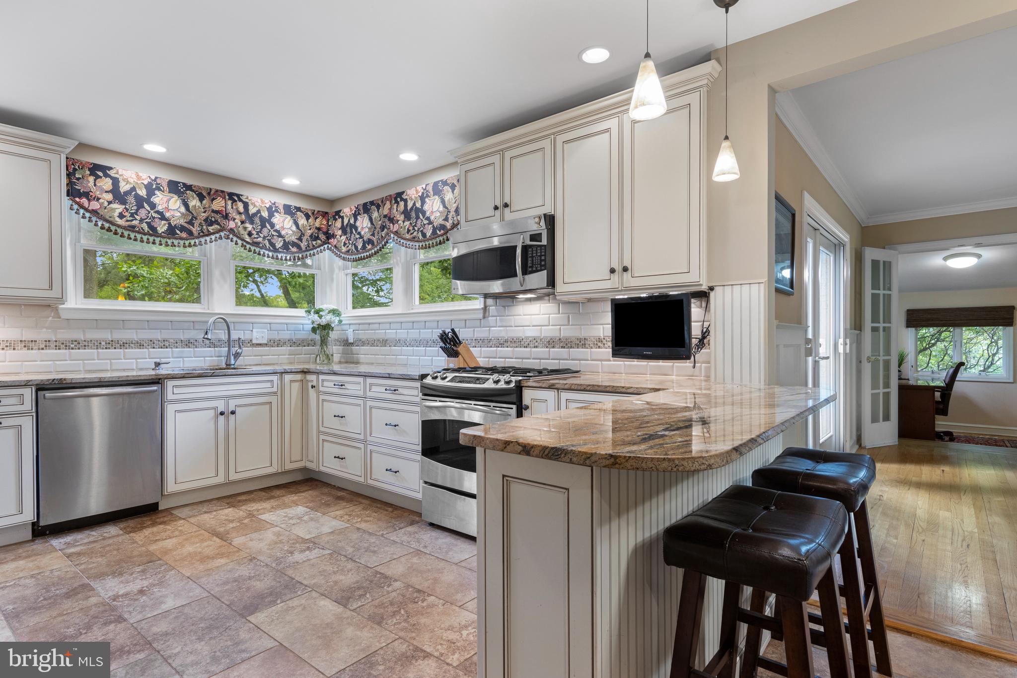413 Hawthorne Road Wallingford, PA 19086 - Photo 21 of 52 a kitchen with stainless steel appliances granite countertop a stove top oven a sink a counter space and cabinets