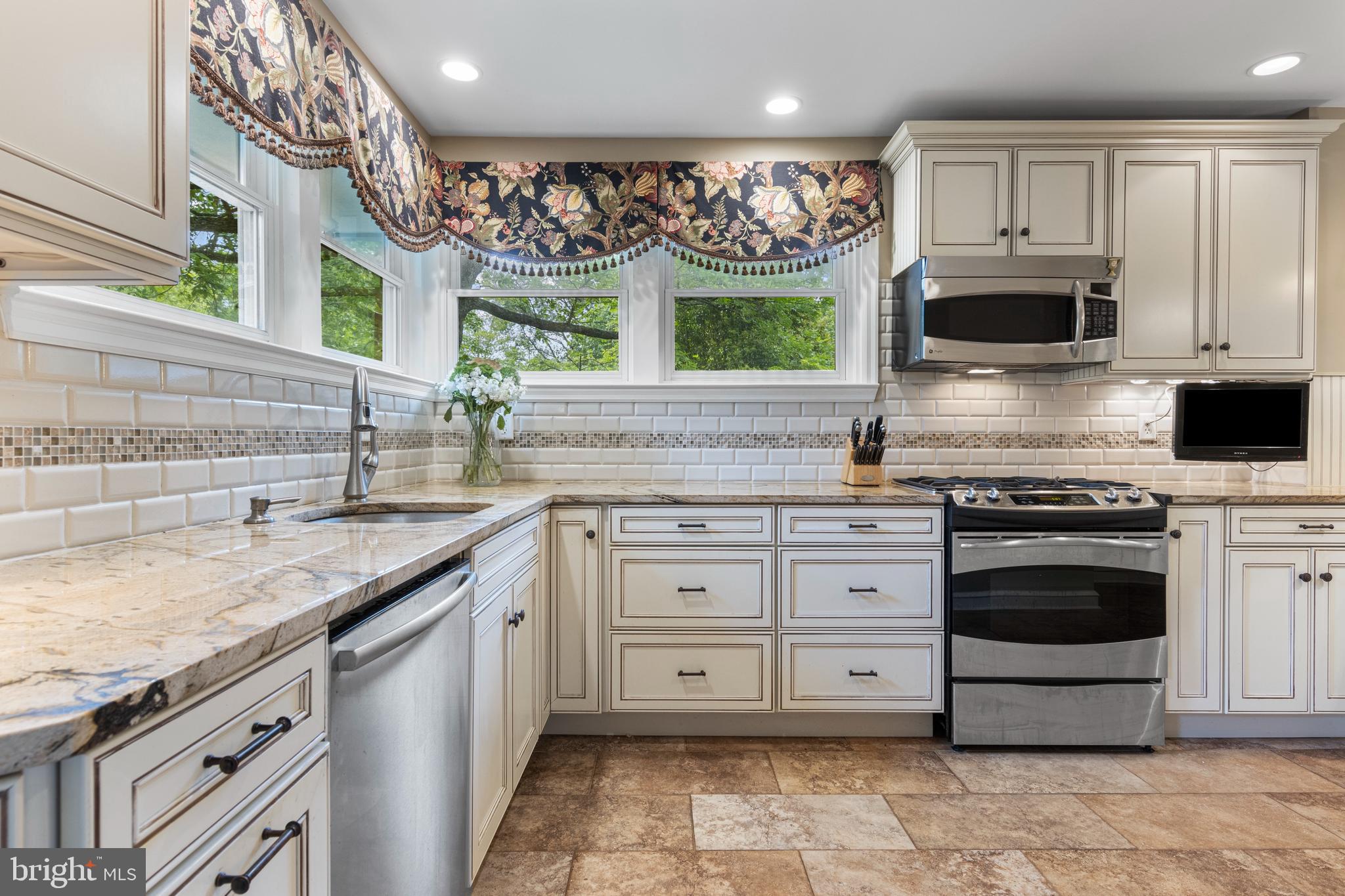 413 Hawthorne Road Wallingford, PA 19086 - Photo 23 of 52 a kitchen with granite countertop a sink stainless steel appliances and cabinets