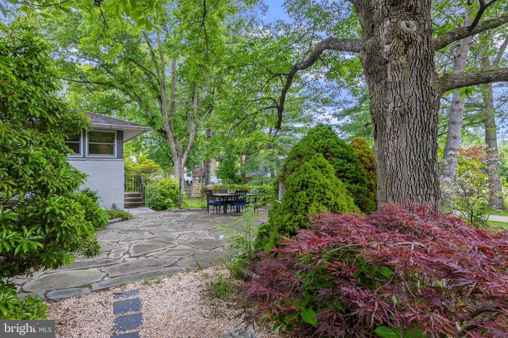 413 Hawthorne Road Wallingford, PA 19086 - Photo 38 of 52 a view of a backyard with table and chairs and a large tree