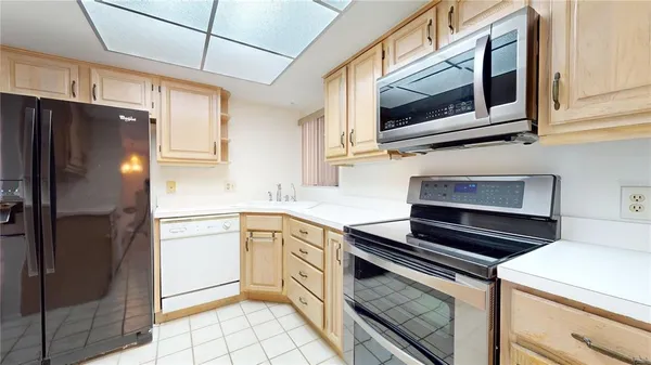a kitchen with stainless steel appliances granite countertop a refrigerator a stove and a sink