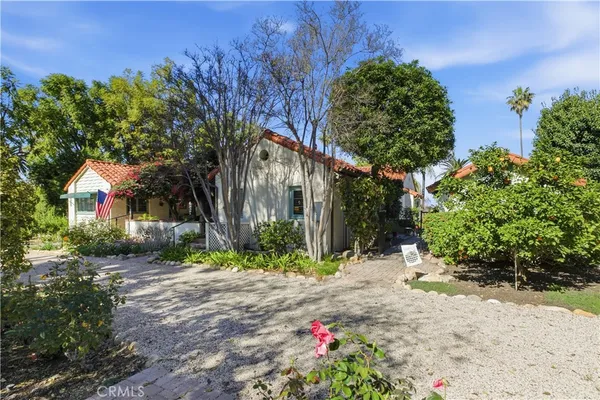 a front view of a house with a yard and potted plants