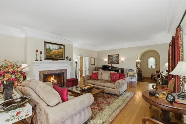 a kitchen with stainless steel appliances kitchen island granite countertop a refrigerator a stove a oven and white cabinets with wooden floors