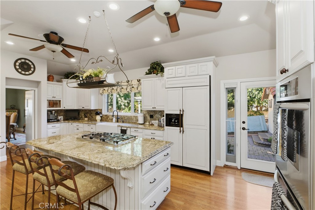 2855 McAllister Street Riverside, CA 92503 - Photo 38 of 75 a kitchen with stainless steel appliances kitchen island granite countertop a refrigerator a stove a oven and white cabinets with wooden floors