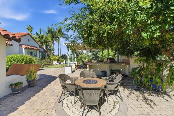 a view of a patio with couches and table and chairs and potted plants