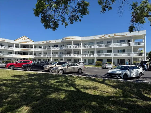 a front view of a building with cars parked