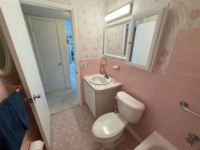 a white toilet sitting next to a bathroom sink and tub