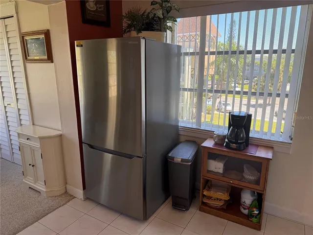 a kitchen with windows and refrigerator