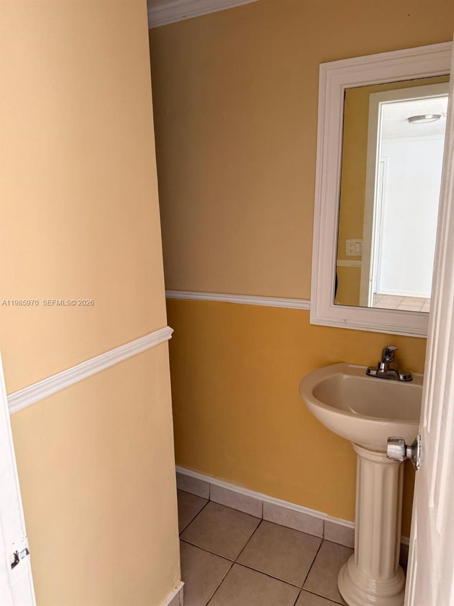409 Northwest 33rd Street, Unit 1 Miami, FL 33127 - Photo 12 of 17 a bathroom with a sink and mirror