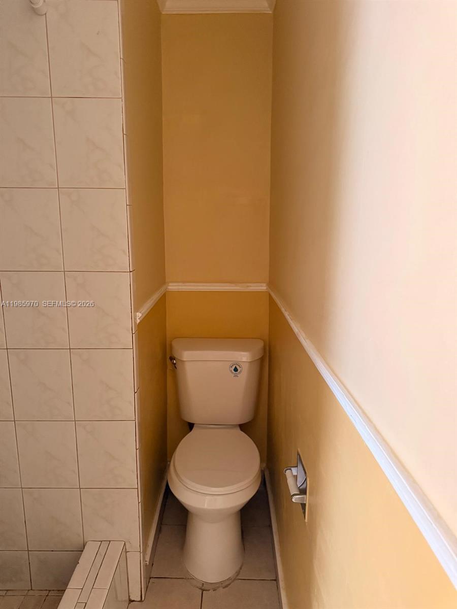 409 Northwest 33rd Street, Unit 1 Miami, FL 33127 - Photo 7 of 17 a white toilet sitting next to a white wall