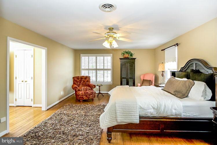 20801 Layton Ridge Drive Gaithersburg, MD 20882 - Photo 14 of 30 a bedroom with a bed and wooden floor