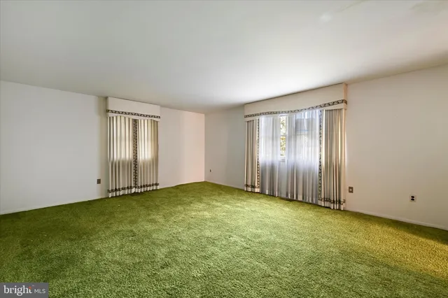 a view of a big room with windows and chandelier