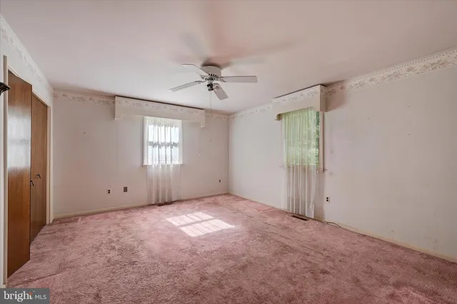 an empty room with windows and closet