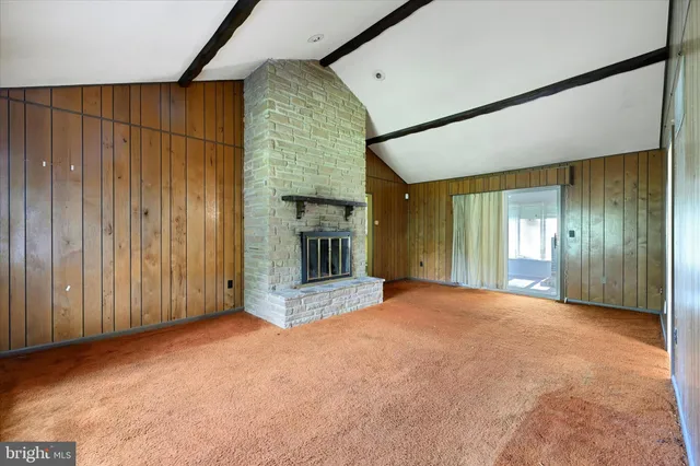 a view of an empty room with a fireplace and a window