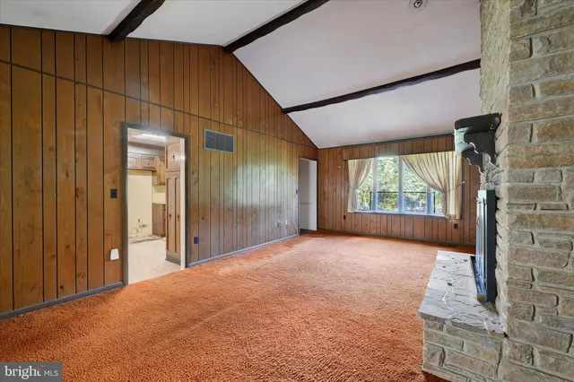 a view of an empty room with a fireplace and a window
