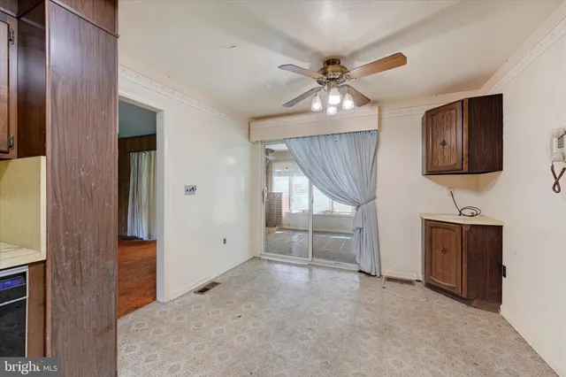 an empty room with ceiling fan and hardwood floor