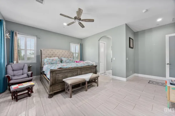 a bedroom with a large bed and a chandelier