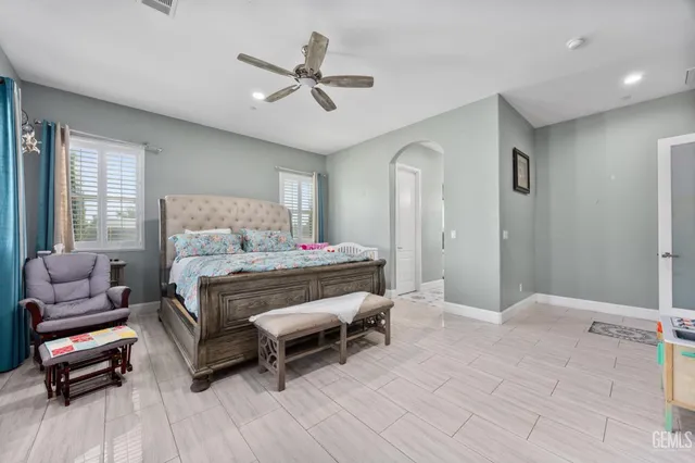 a bedroom with a large bed and a chandelier