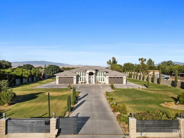 a large white kitchen with stainless steel appliances granite countertop lots of white cabinets a stove and sink