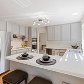 a kitchen with a refrigerator a stove a sink dishwasher with a dining table and chairs